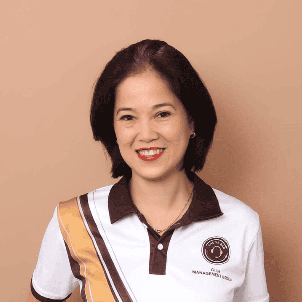Portrait of a smiling woman in a VA Bar uniform against a beige background.